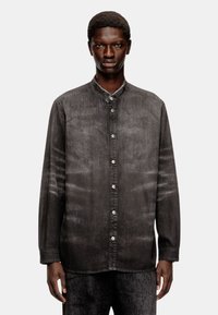 Chemise en denim gris foncé avec un col mandarin, fermeture à boutons, manches longues et variations de texture subtiles. AUCUN motif ou accent visible.