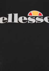Czarna koszulka z okrągłym dekoltem, z dużym białym nadrukiem "ellesse" oraz wielokolorowym logo z żółtymi, czerwonymi i białymi akcentami.