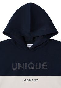 Felpa con cappuccio blu navy con testo bianco "UNIQUE" impreziosito da riflessi lucidi, e "MOMENT" sotto, realizzata in tessuto morbido con una texture liscia.