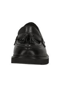 Mocassin en cuir noir avec détail de pompon sur le dessus, bout arrondi et semelle en caoutchouc épaisse, vu de face sur fond blanc.