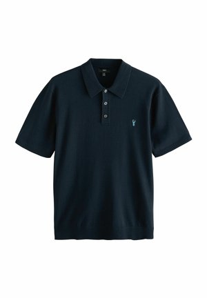 Polo de manga corta en color navy, fabricado en tejido de punto, con un cuello clásico, tapeta de tres botones y un pequeño logotipo bordado.