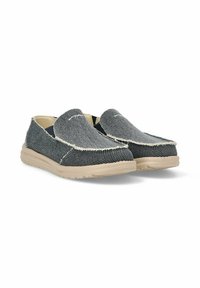 Zapatos slip-on de lona en gris oscuro con acabado texturizado, costuras en crema y suela beige flexible. Diseño de punta redonda y corte bajo.