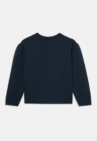 Marinblå långärmad topp med rundad halsringning, som har lätt puffade ärmar och rak nederkant. Mjuk textur med minimal sömdetalj.