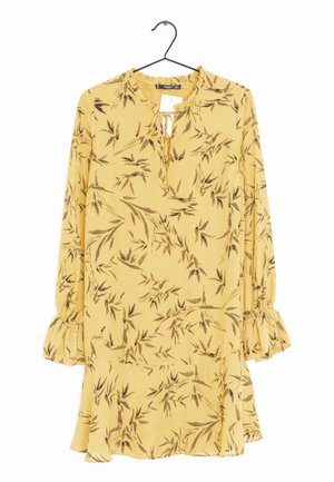 Gelbes Kleid mit einem braunen Blumenmuster, langen Ärmeln, Rüschensaum und einem Schlüssellochausschnitt. Hergestellt aus leichtem Stoff, fließendes Design.