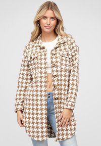 Șacket cu model houndstooth în nuanțe de bej și maro, având un design cu guler, închidere cu nasturi, două buzunare pe piept și o croială relaxată.