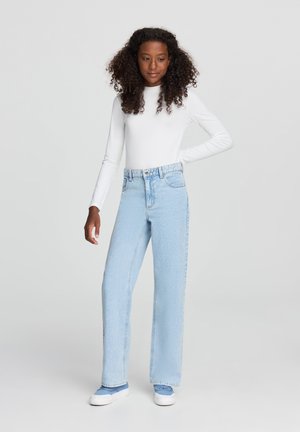 Jasnoniebieskie dżinsy z wysokim stanem o luźnym kroju, z delikatnym wyblaknięciem, przednimi kieszeniami oraz pasem z zapięciem na metalowy guzik.