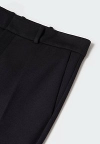 Pantalones negros de corte recto confeccionados en una tela suave, con cinturilla y trabillas para cinturón, y pliegues delanteros bien planchados.