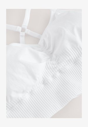 Hvid bralette med justerbare stropper, der har en tekstureret samling i midten og et ribbet bånd for støtte. Glat stof finish.