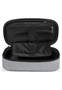 Pochette in tessuto grigio con chiusura a zip. L'interno presenta un tessuto nero, una tasca con zip e bande elastiche per organizzare gli oggetti.
