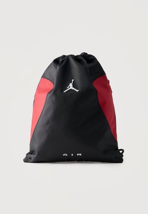 Sac de sport à cordon noir et rouge avec le logo Air Jordan et le texte "AIR" sur le devant, posé debout sur un fond uni.