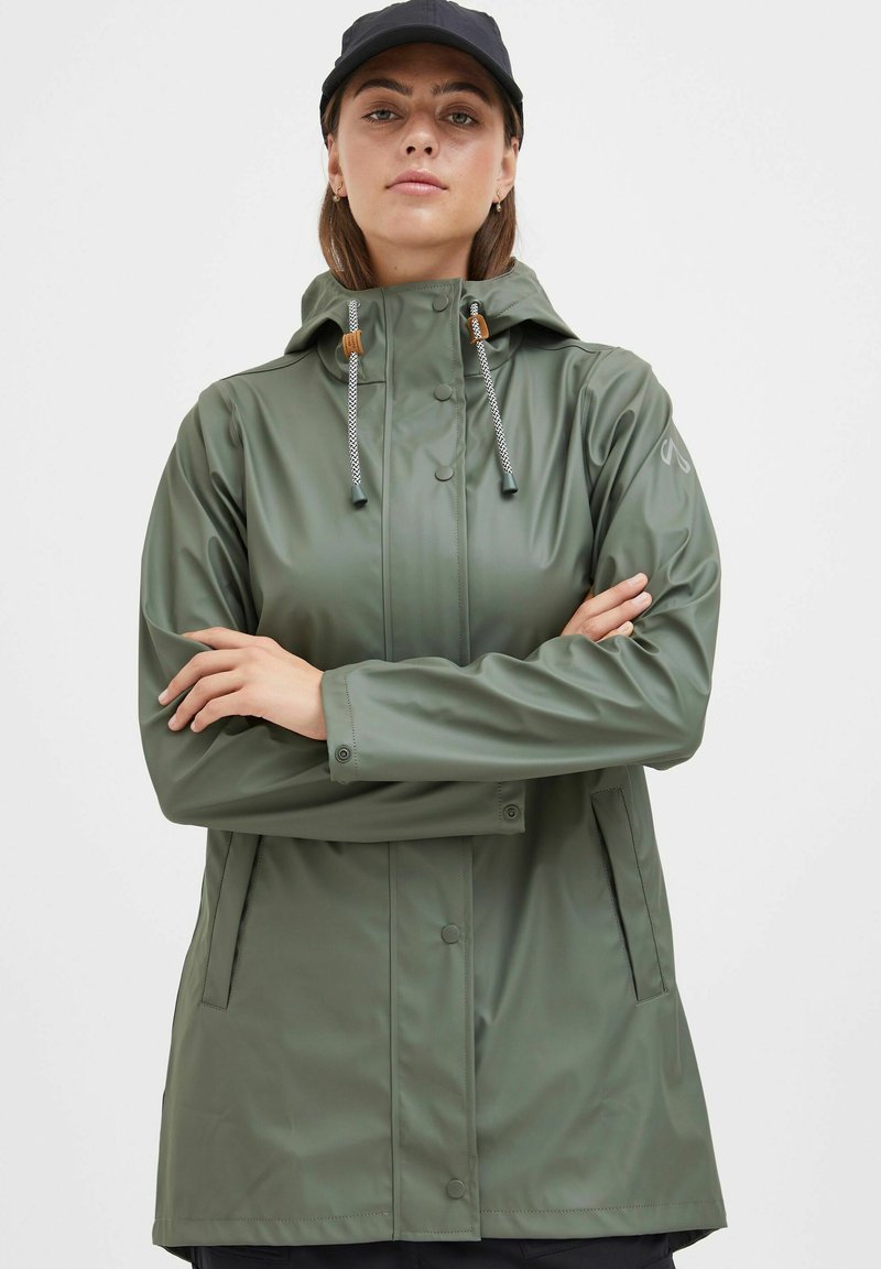 Green waterproof rain jacket with a hood, front snap closure, adjustable drawstrings, and side pockets. Smooth, shiny texture.
