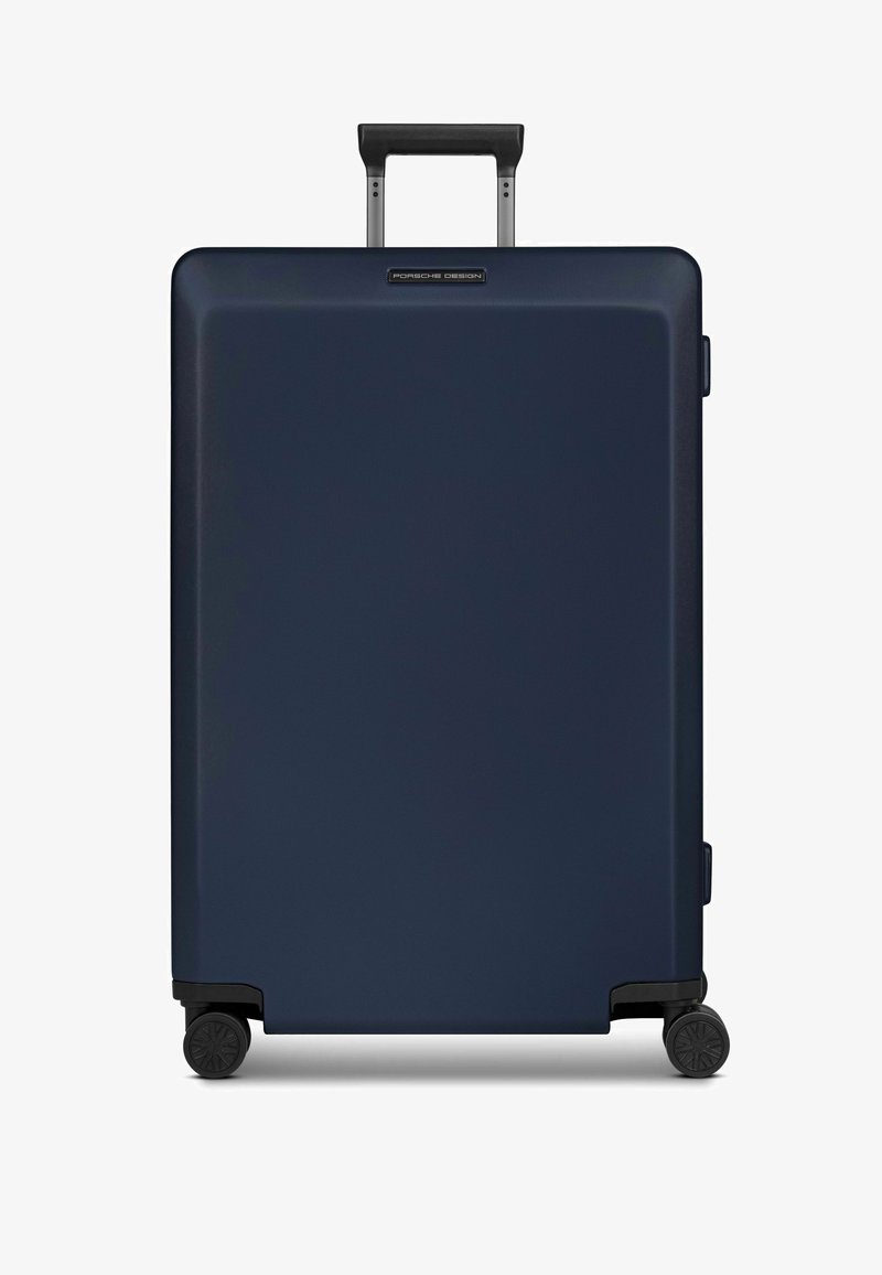 Maleta rígida azul marino con acabado texturizado, mango retráctil y cuatro ruedas negras para facilitar la movilidad. Logotipo visible en la parte frontal.