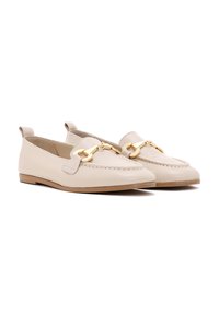 Mocassini in pelle beige con punta rotonda, caratterizzati da un dettaglio cucito e accenti in metallo dorato. Suola piatta e design alla calzatura slip-on.