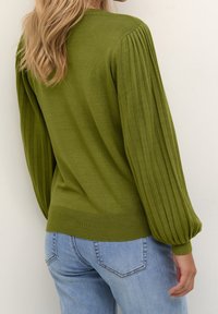 Maglione verde a maglia con maniche a palloncino plissettate, polsini e orlo a coste, abbinato a jeans azzurri, che mette in mostra il dettaglio posteriore su uno sfondo neutro.