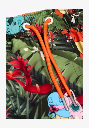 Grønne badshorts med et tropisk blomsterprint, prydet med orange snore og øjer, der viser forskellige tegneseriefigurer.