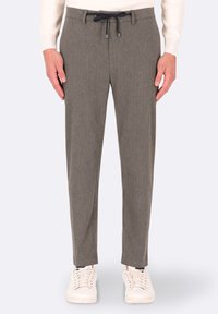 Pantaloni grigi a sigaretta realizzati in tessuto testurizzato con una coulisse in vita. Abbinati a sneakers bianche per un look informale.