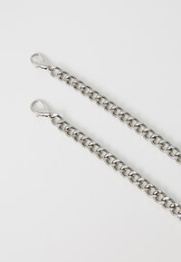 Chaîne en métal avec des segments entrelacés, finition en argent brillant. Présente un fermoir de type homard à une extrémité. Surface lisse et épaisseur uniforme.
