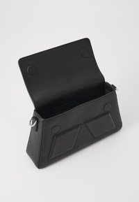 Black leather bag with a geometric design. Features a flap closure, two front pockets, and a smooth texture. Open interior, minimal hardware.