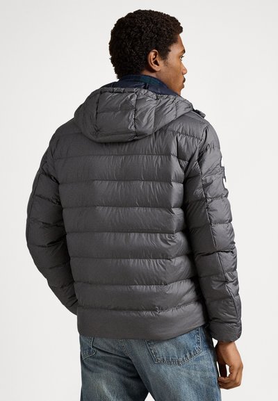 Šedá prešívaná bunda s kapucňou, s prešívanými sekciami a hladkou textúrou. Dizajn zahŕňa kontrastnú vnútornú podšívku a bočnú nášivku s logom.