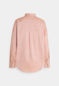 Różowa, długosleeve'owa koszula z lekkiego materiału. Posiada kołnierzyk zapinany na guziki, plisę z tyłu oraz mankiety zapinane na dwa guziki. Gładka faktura.
