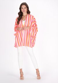 Lys pink og orange stribet kimono med brede ærmer, let stof, åben front og en afslappet pasform, parret med hvide bukser.