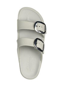 Sandalo bianco con due cinturini regolabili, fibbie argentate e una superficie liscia. Presenta una soletta imbottita con il marchio "Skechers".
