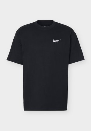 T-shirt nera a maniche corte con scollo rotondo e piccolo logo bianco Nike swoosh sul petto sinistro, mostrata su uno sfondo chiaro e semplice.