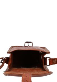 Bruine leren crossbodytas met open klep die een lege binnenkant en zilveren gesp toont op een witte achtergrond.
