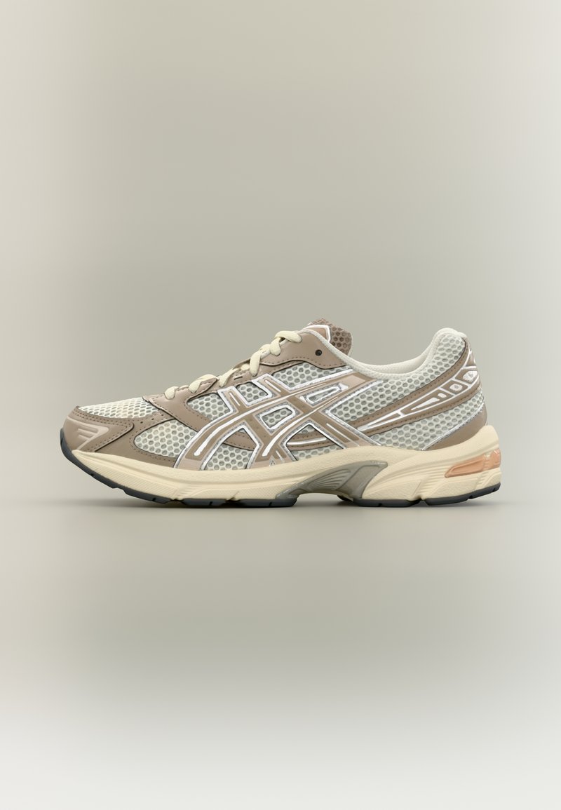 Zapatillas deportivas con parte superior de malla en crema y beige con detalles en blanco, puntera redonda, collar acolchado y suela de goma texturizada.