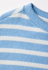 Pull bleu clair à rayures blanches avec un col rond. Tissu tricoté doux et texturé. Des rayures larges alternent en motif sur la zone de la poitrine.