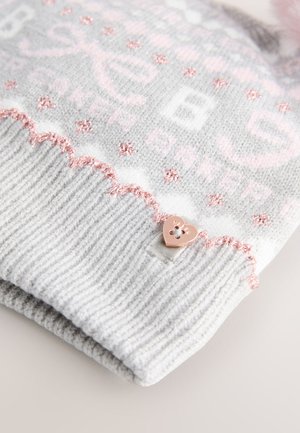 Szürke kötött sapka világos rózsaszín hullámos szegéllyel, szív alakú fém díszítéssel és mintás varrással, mely világos rózsaszín és fehér színekben készült.