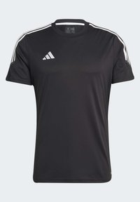 Svart atletisk t-shirt gjord av lättviktig tyg. Har rund hals, korta ärmar och tre vita ränder längs axlarna.