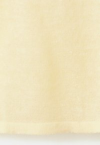 Țesătură tricotată galben deschis, cu cusături fine și uniforme și o textură moale, prezentând detaliul marginii inferioare.