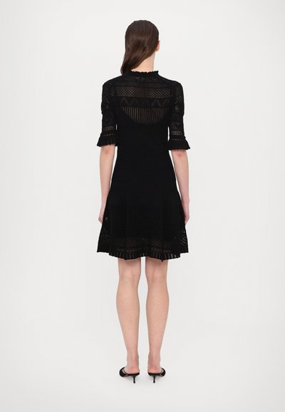 Schwarzes gestricktes Kleid mit kurzen Ärmeln, das mit Spitzenmustern, einem taillierten Oberteil und einem ausgestellten Rock gestaltet ist. Strukturiertes und durchbrochenes Design.