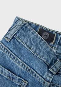 Jeans aus Denim in einem verblassten Blauton, mit kontrastierendem gelbem Nähen, vier Taschen und einem schwarzen Metallknopf am Bund.