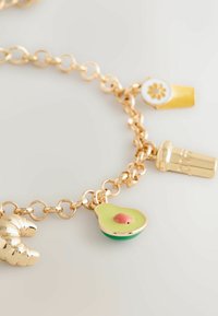 Gold-tone chain bracelet featuring four charms: a croissant, an avocado with a pink pit, a yellow drink with a flower, and a trash can.