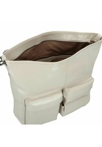 Middelgrote, lichtbeige leren tas met twee voorkostructuren, een ruime binnenkant en een ritssluiting. Gladde textuur met minimale hardware.
