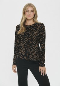 Pika-särkmustriga musta ja pruuniga pikad varrukad, millel on ümmargune kaelus ja nööpide sulgemine ees. Pehme kudumise tekstuur.