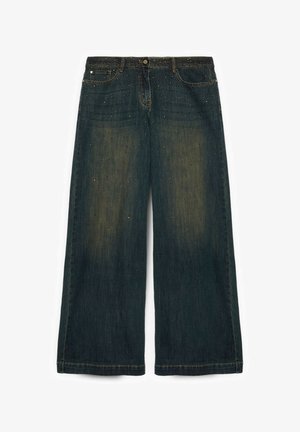 Pantalones vaqueros de pernera ancha y oscura con un sutil desgaste y pequeñas tachuelas decorativas repartidas por la tela.