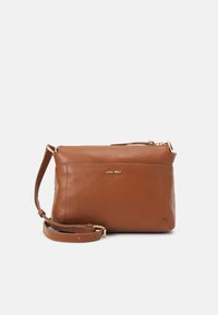 Brown leather crossbody bag with a smooth texture, golden hardware accents, and a zip closure. Adjustable strap attached.