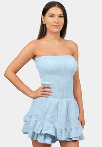 Robe bleu clair sans bretelles avec corsage froncé et ourlet à volants. Fabriquée en tissu texturé, avec des volants superposés au niveau de la jupe.