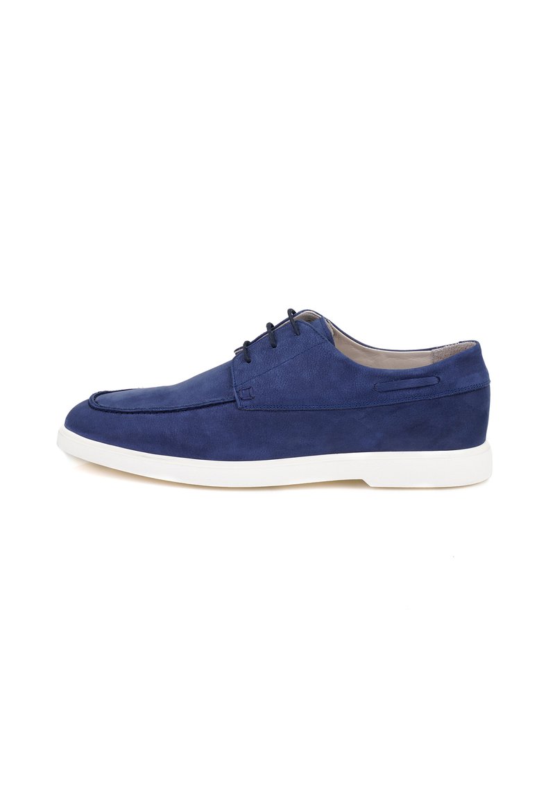 Chaussure en cuir suédé bleu avec un bout arrondi, cinq lacets et une semelle en caoutchouc blanche. Présente un bord cousu et des détails de design minimalistes.