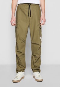 Olivgrüne Cargo-Hosen mit verstellbarem Kordelzugbund, seitlichen Taschen, lockerer Passform und einer glatten, leichten Stofftextur.