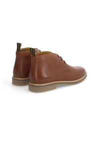 Bottines en cuir marron avec une finition lisse, bout rond et design à lacets. Présentent une semelle texturée de couleur claire et un marquage sur le talon.