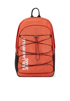 Orange rygsæk med sorte elastikledninger, sort håndtag og hvidt lodret tekst "KARL LAGERFELD JEANS" på forsiden, vist mod hvid baggrund.