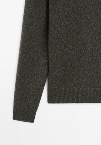 Dunkelgrauer, gestrickter Wollpullover mit Ärmel und Saum sowie gerippten Bündchen und Taillierung auf einem weißen Hintergrund.