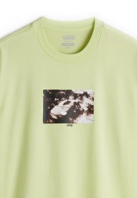 Lichtgroen katoenen t-shirt met een losse pasvorm. Heeft een rechthoekige zwart-wit grafische print in het midden met "VANS" tekst eronder.