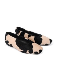 Czarne i beżowe baleriny w wzór cowski z miękką futrzaną teksturą i kwadratowym noskiem. Podeszwa jest płaska i minimalistycznie stylizowana.