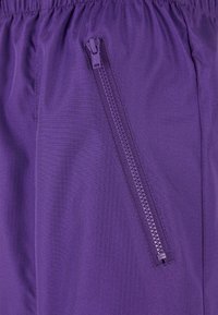 Lilla shorts med teksturert stoff, som har en sikker sidelomme med glidelås og en elastisk midje for justerbar passform.
