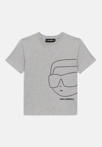 Pelēks kokvilnas T-krekls ar melnu punktiņu grafiku, kurā attēlotas brilles un seja uz priekšpuses. Uz etiķetes apakšējā daļā ir rakstīts "KARL LAGERFELD".